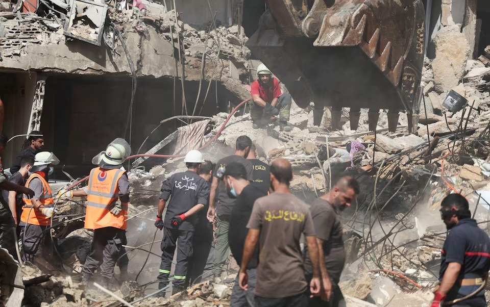 Petugas darurat bekerja di lokasi serangan Israel pada hari Jumat, sementara operasi pencarian dan penyelamatan terus berlangsung, di pinggiran selatan Beirut, Lebanon, 21 September 2024. REUTERS/Amr Abdallah Dalsh.