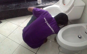 Petugas Jasa Bersih Rumah saat membersihkan kloset duduk salah satu pelanggan.